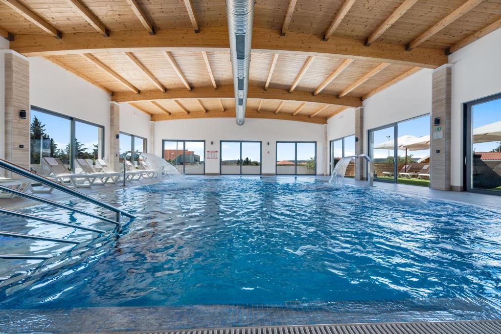 a swimming pool with a water slide in a building at Apartmani Rubinić in Turanj