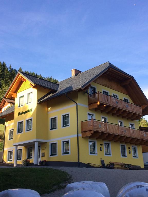 ein großes gelbes Gebäude mit Balkonen darauf in der Unterkunft Appartement Döringerhof in Aich