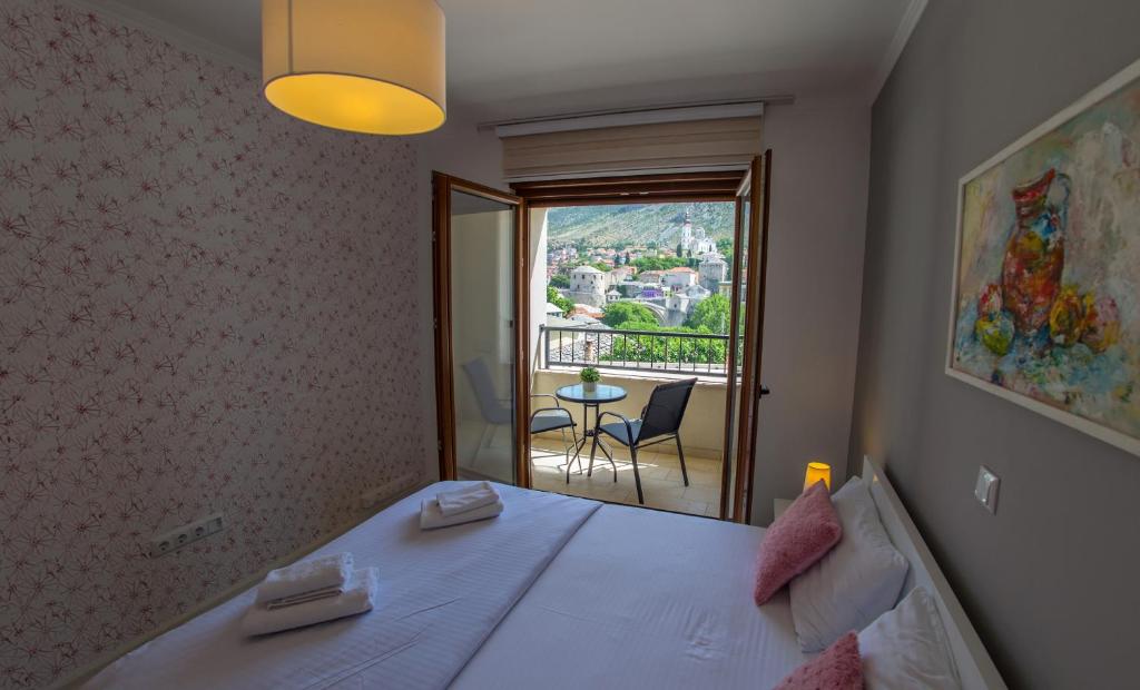 a bedroom with a bed with a view of a balcony at Apartment Light De Luxe - with Old Bridge view in Mostar
