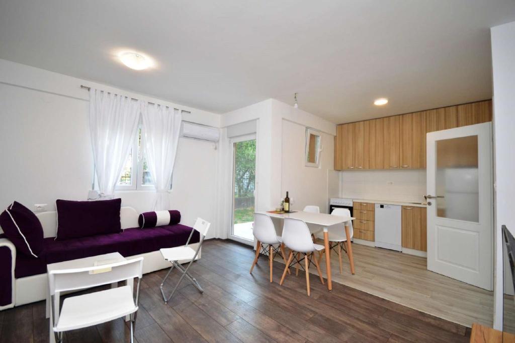 a kitchen and a living room with a couch and a table at Apartments Nina Tivat in Tivat