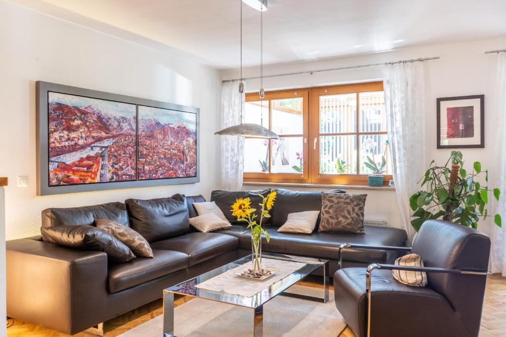 sala de estar con sofá de cuero y mesa en Apartment Salzburg City&Lake, en Elixhausen