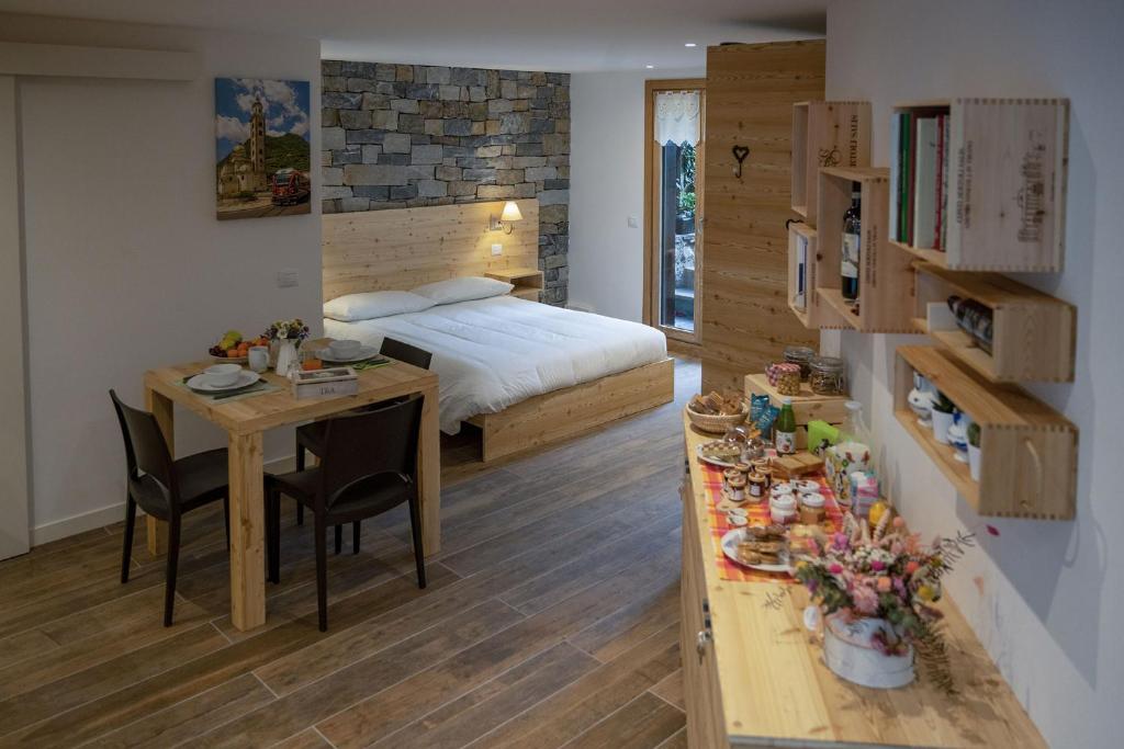 een slaapkamer met een bed en een tafel met stoelen bij Casa Galèt in Tirano
