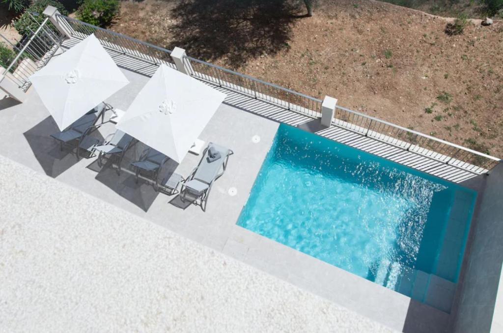 an overhead view of a swimming pool with chairs and umbrellas at Villa Ona in Port de Soller
