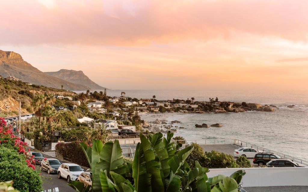 een uitzicht op een strand met geparkeerde auto's bij Clifton Studio in Kaapstad