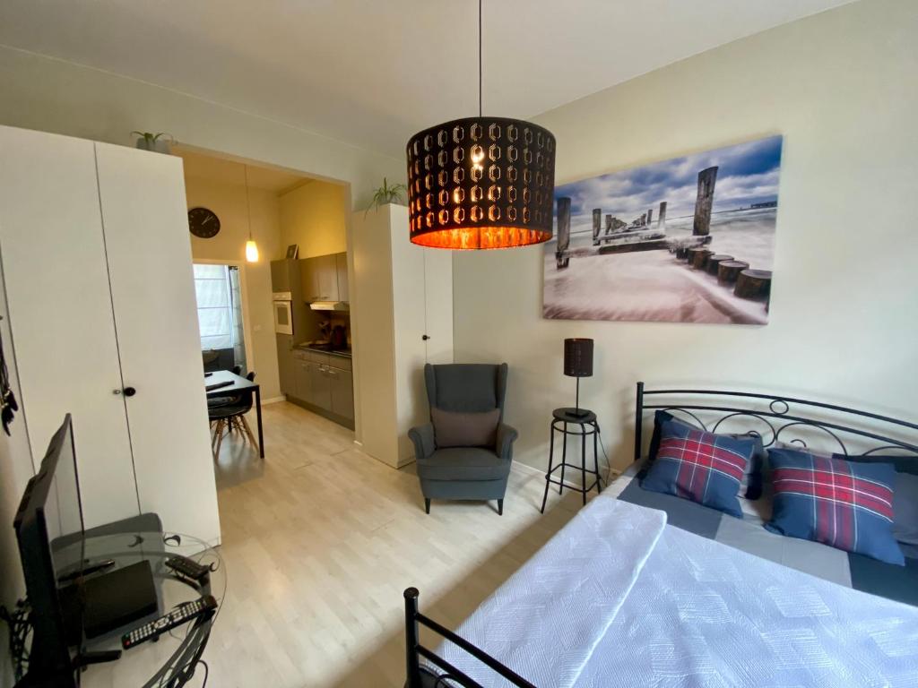 Petit Appartement Jourdan EU في بروكسل: غرفة نوم بسرير وتلفزيون في غرفة