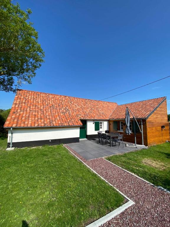 une maison avec un toit rouge et une terrasse dans l'établissement Cottage Naomie, à Rue