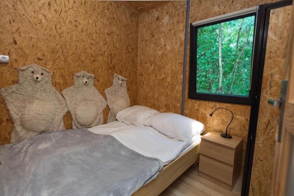 una habitación con una cama con cuatro animales de peluche en la pared en Bogacki Domek, en Giżycko