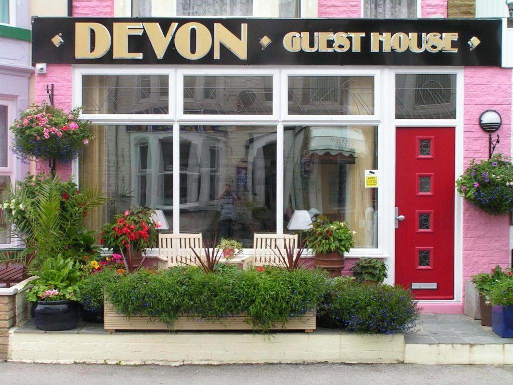 een winkel met een rode deur en een devon pension bij Devon Guest House in Blackpool