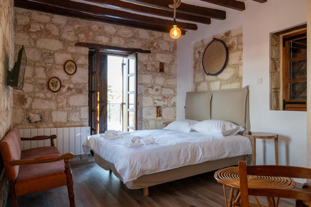 1 dormitorio con 1 cama en una habitación con paredes de piedra en Droshia Traditional Homes, COCO-MAT Full Experience, en Droushia