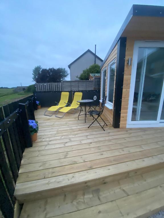 a wooden deck with chairs and tables on a house at Number Fifty Six in Saint Monance