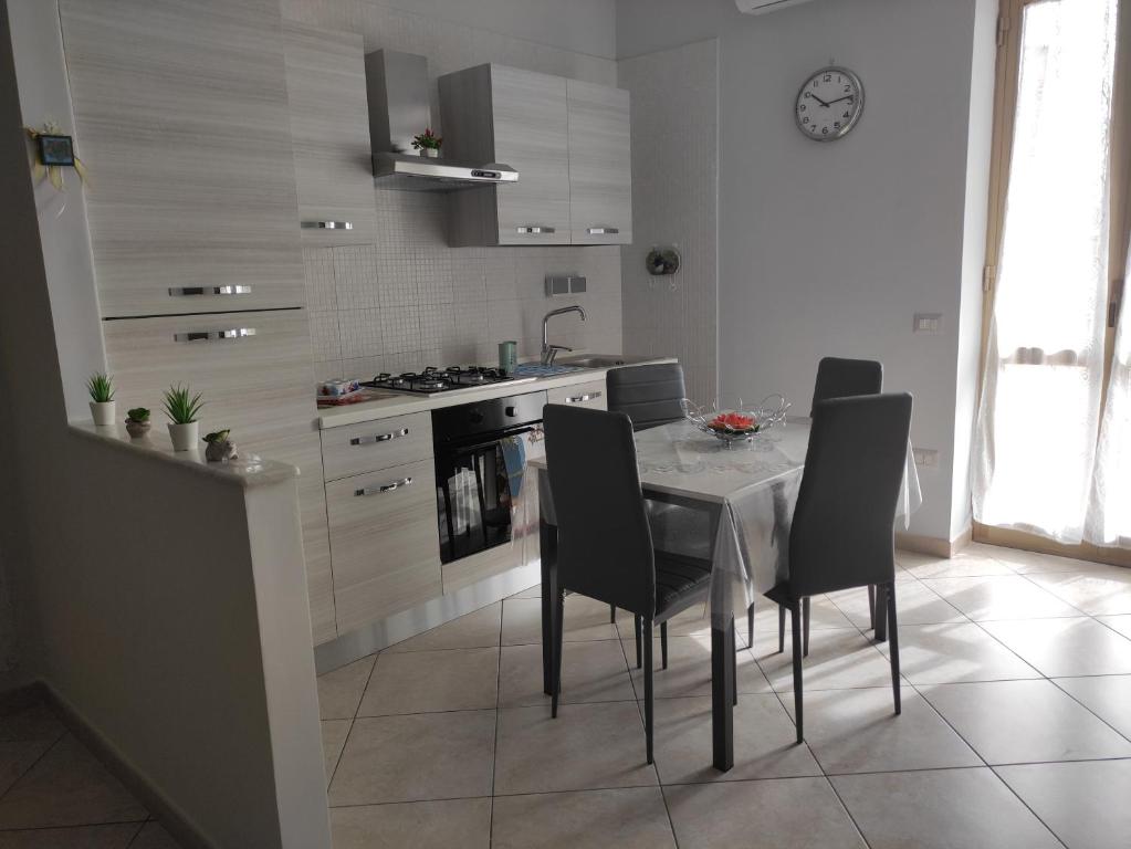 uma cozinha com uma mesa, cadeiras e um fogão em La quiete del Vesuvio em Nápoles