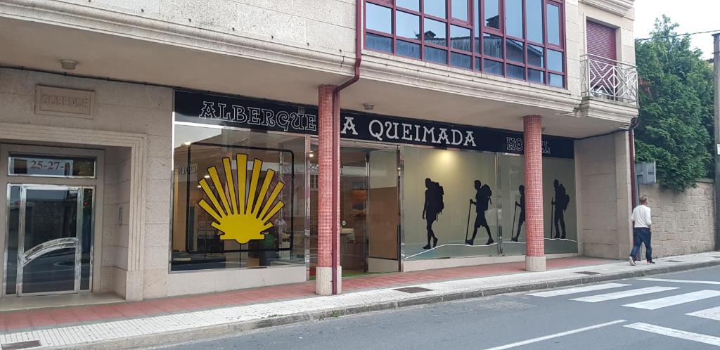 een winkelgevel met een geel bord op het raam bij albergue a queimada in Caldas de Reis