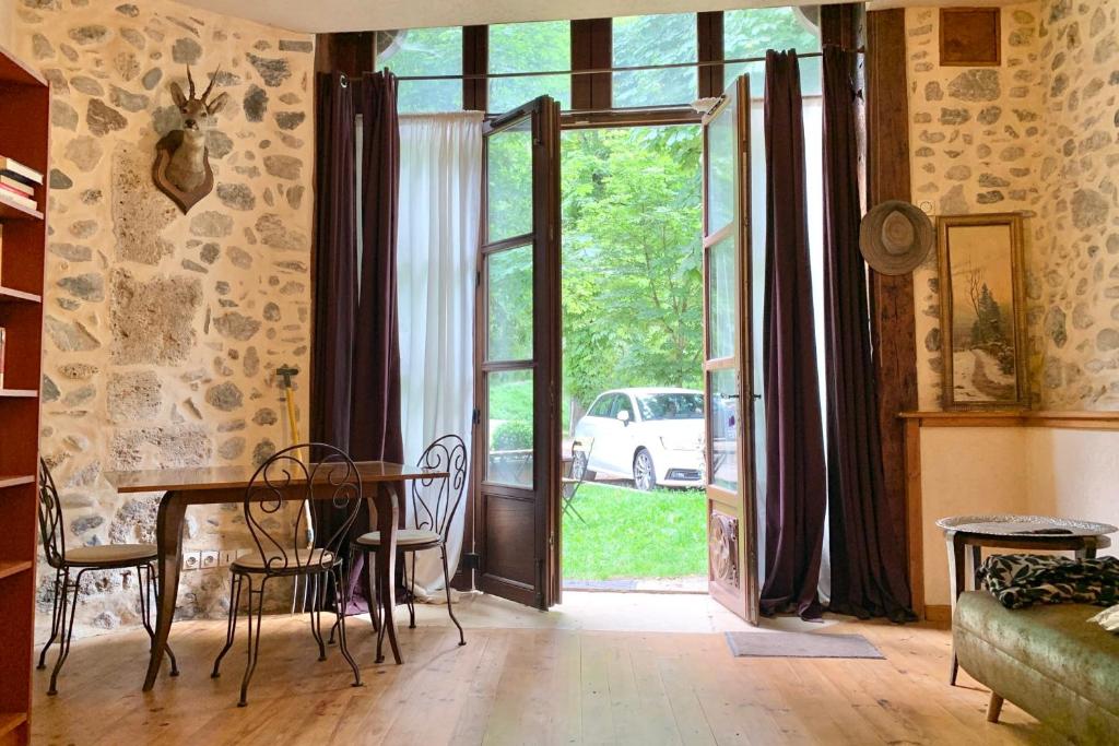 - un salon avec une table et une porte en verre dans l'établissement The Uriage Castle #BV, à Saint-Martin-dʼUriage