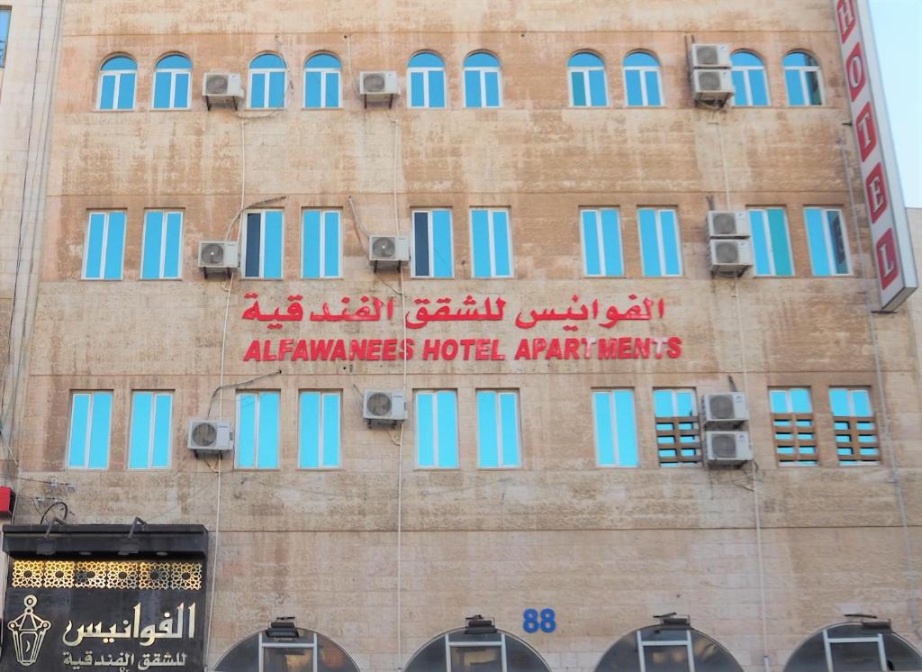 budynek z niebieskimi oknami i znakiem na nim w obiekcie Al Fawanes Hotel Apartments w mieście Amman