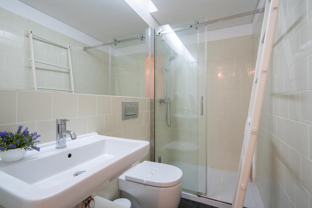 a bathroom with a toilet and a sink and a shower at OPO Downtown Blue in Porto