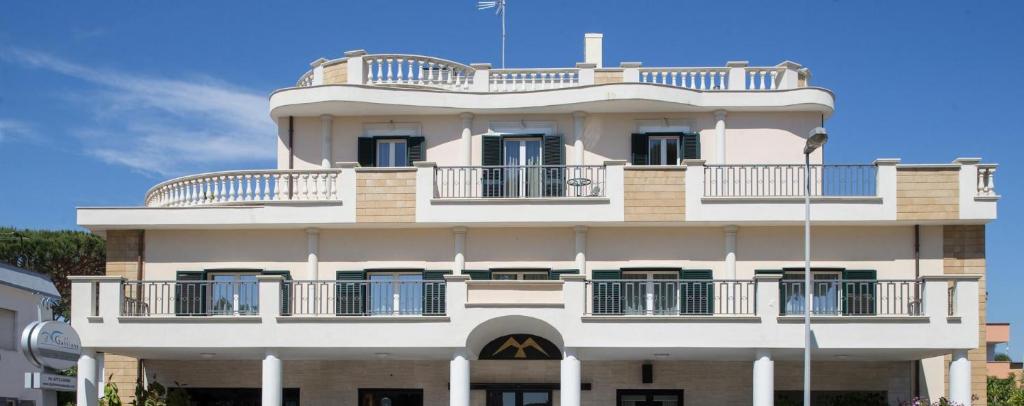 a tall white building with balconies on it at Hotel Il Gabbiano in Sabaudia