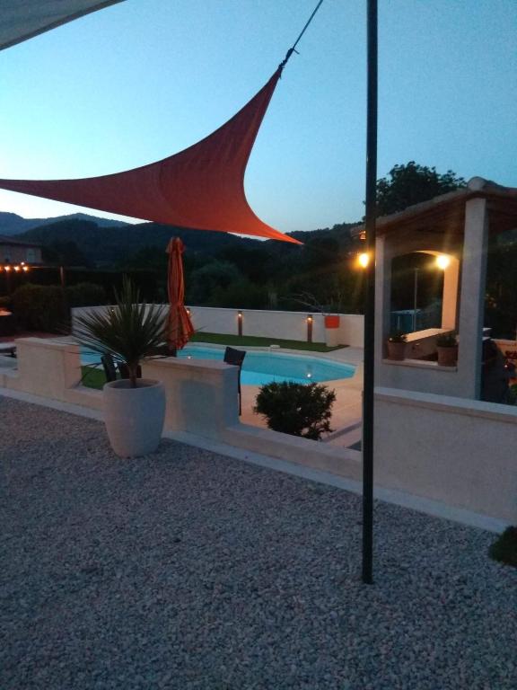 - un parasol au-dessus de la piscine la nuit dans l'établissement Lobeal, à Auriol