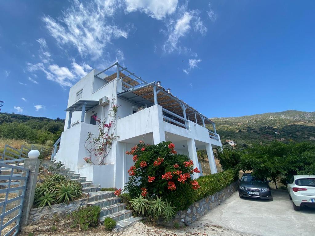 a white house with flowers in front of it at Agnanti in Akhladherí