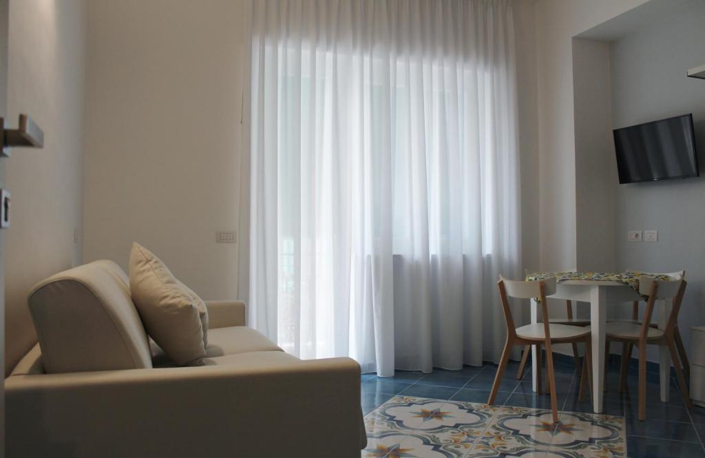 uma sala de estar com um sofá e uma mesa em Divina Holiday - Apartments em Maiori