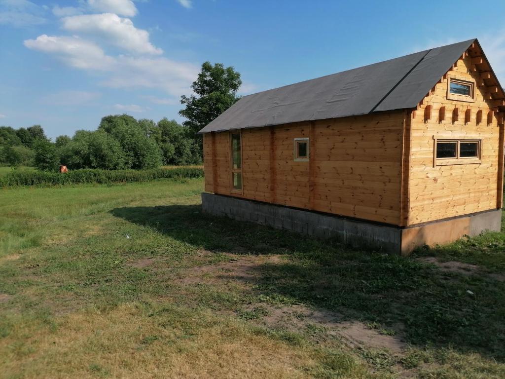 a small wooden building in a field at Domek na bagnie in Radziłów