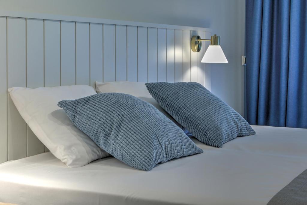 a bed with two pillows on top of it at Marine Hotel Jūrmala in Jūrmala