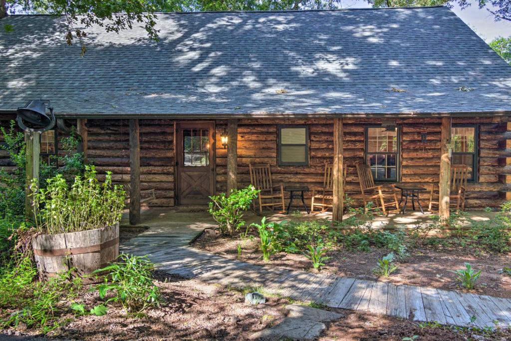 Cabaña de madera con porche y sillas en Secluded Cabin with Spacious Kitchen and Dining Area!, en Sunset