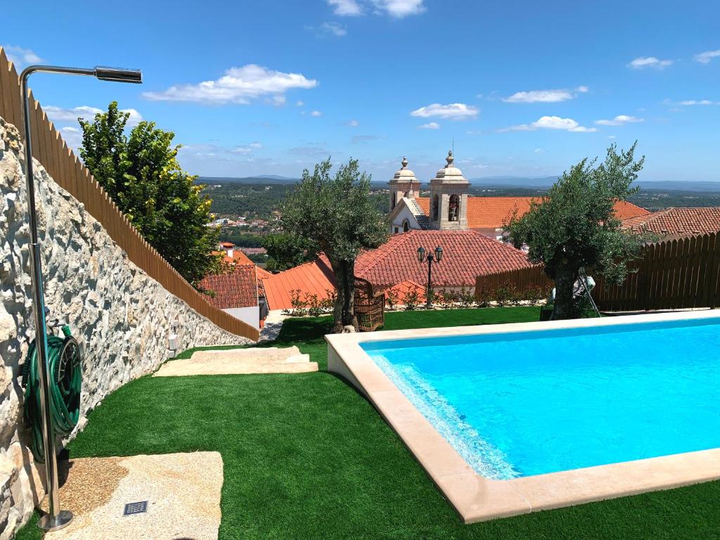 a swimming pool in front of a house at Casa Varanda do Castelo in Ourém