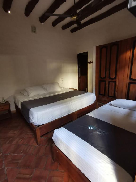 two beds in a room with at Las Cabezas Grises in Barichara