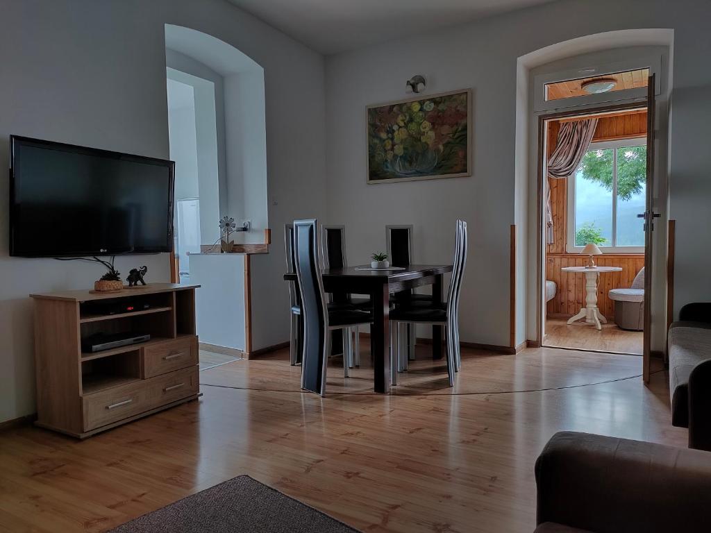 a living room with a table and chairs and a television at Apartamenty Złoty widok in Karpacz