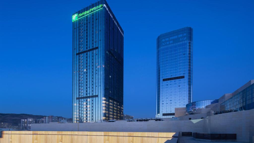 two tall skyscrapers in a city at night at Holiday Inn & Suites Lanzhou Center, an IHG Hotel in Lanzhou