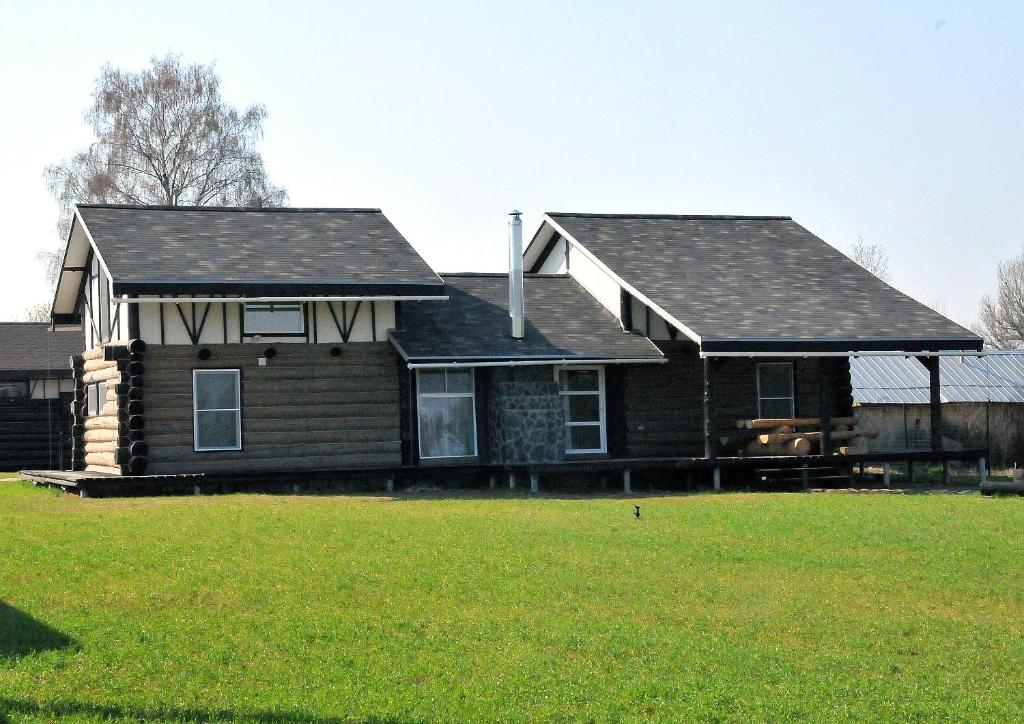 a house with a roof on top of a yard at Chalet Zavidovo Golf in Zavidovo