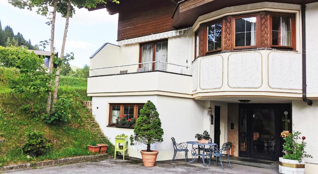 Biały dom ze stołem i krzesłami przed nim w obiekcie Ferienwohnung w mieście Bad Kleinkirchheim