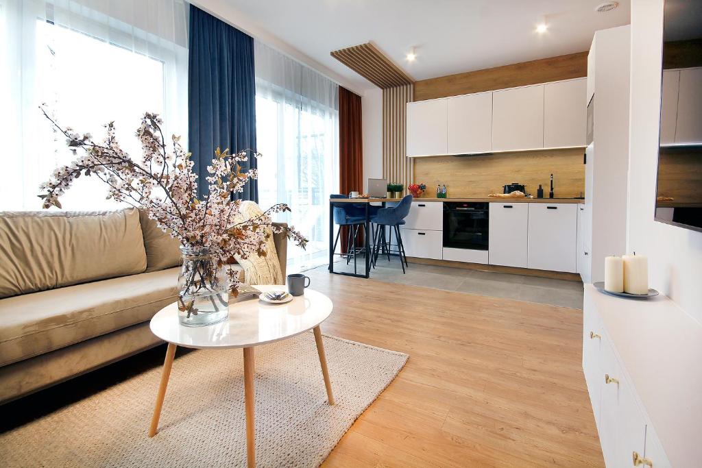 - un salon avec un canapé et une table dans l'établissement W&K Apartments - Harmony Suite, à Koszalin