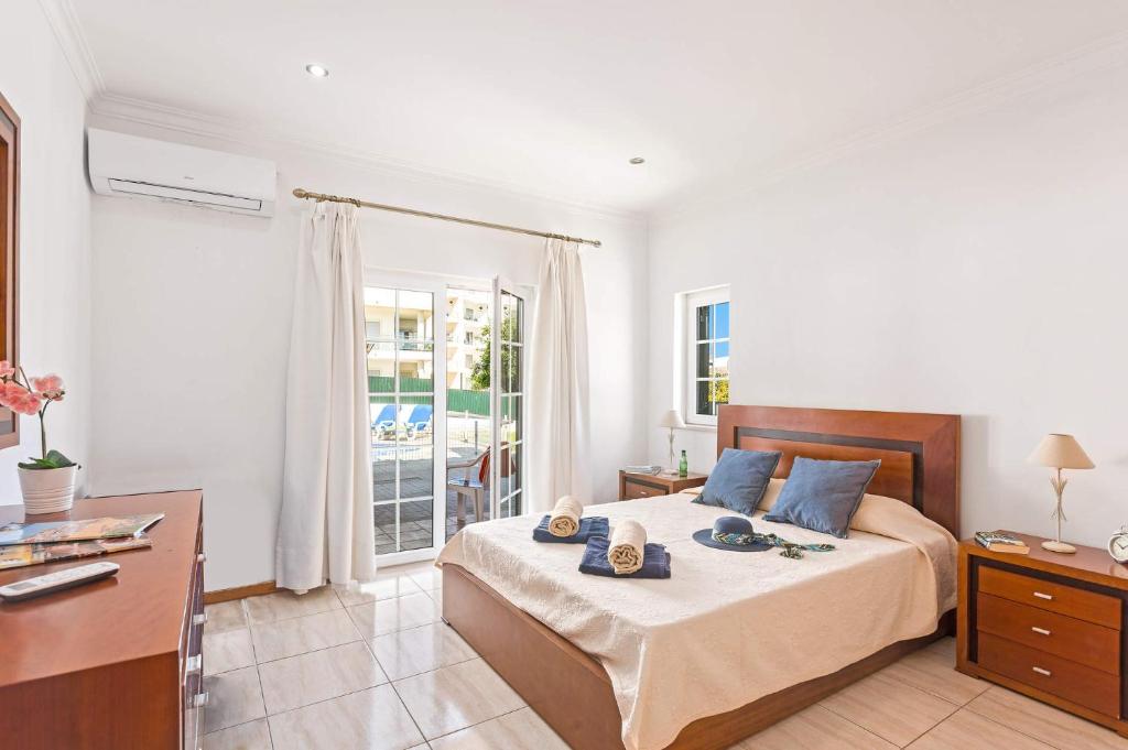 una camera con letto, scrivania e finestra di Villa Carvalho by Villa Plus ad Albufeira