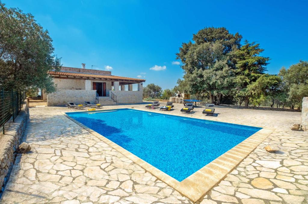 une piscine dans une cour avec une maison dans l'établissement Villa Iolanda by Villa Plus, à Ostuni