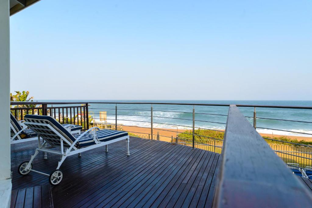 a deck with a chair and the beach at Boathouse Ballito in Ballito