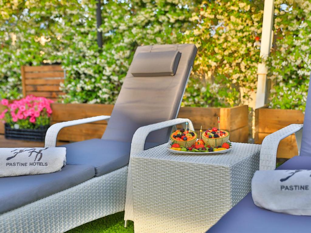 two chairs and a table with a bowl of fruit at Hotel Tigullio Et De Milan in Santa Margherita Ligure