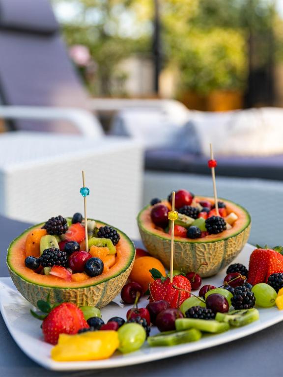 two bowls of fruit on a plate with tooth picks at Hotel Tigullio Et De Milan in Santa Margherita Ligure