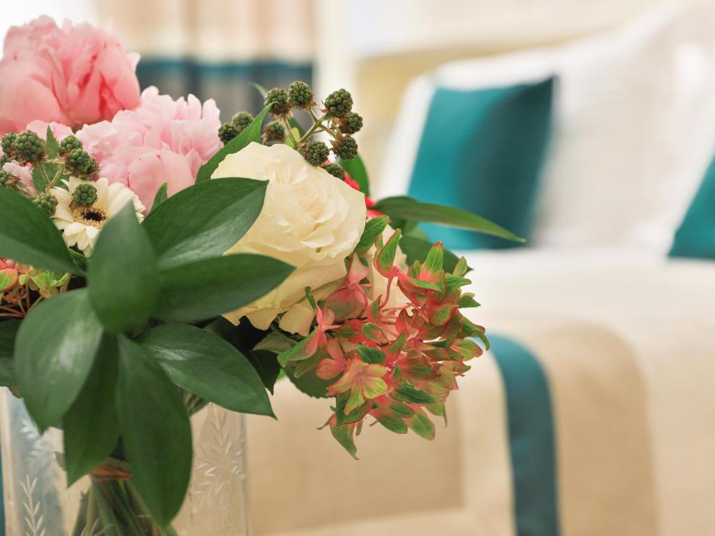 a vase with a bouquet of flowers in it at Hotel Tigullio Et De Milan in Santa Margherita Ligure