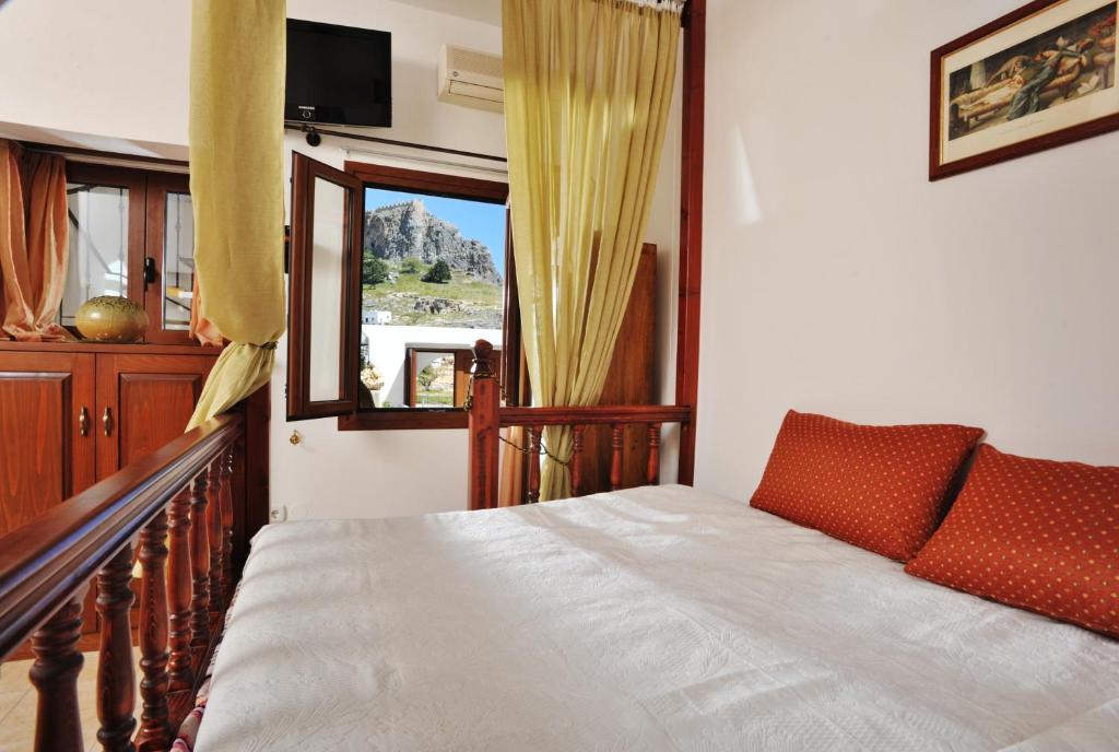 a bedroom with a bed and a window at Lindian Jewel Exclusive Apartments in Líndos