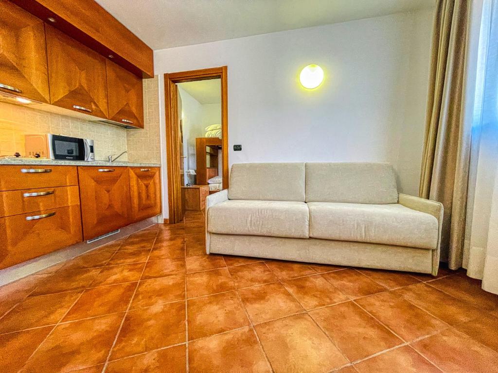a living room with a couch and a kitchen at Appartamento Smith Barbera - Affitti Brevi Italia in Bardonecchia
