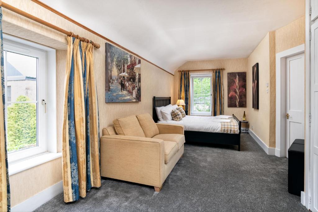 um quarto com uma cama, um sofá e uma janela em The Green Inn Rooms em Ballater