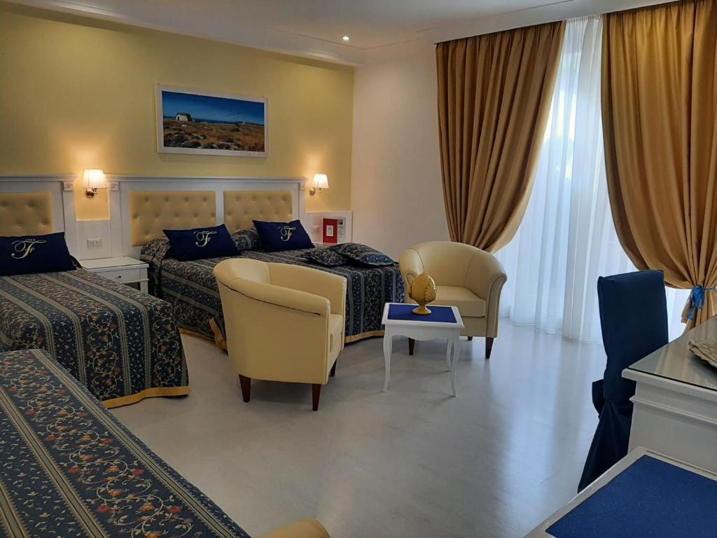 um quarto de hotel com duas camas e duas cadeiras em Falli Exclusive Rooms and Breakfast em Porto Cesareo