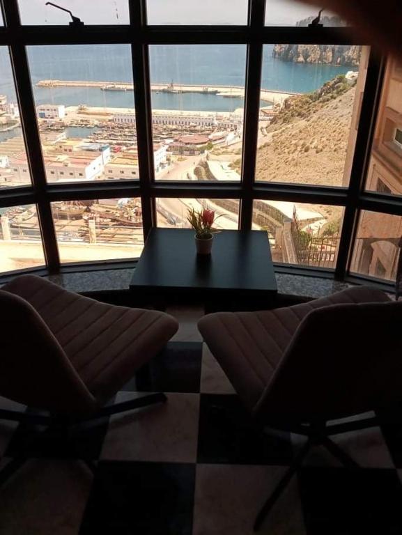 a room with a table and chairs and a large window at Al-marsa2 in Al Hoceïma