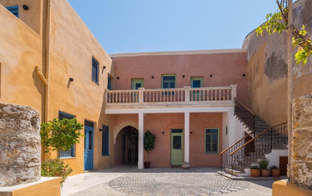 an alley in an old house with a staircase at Casa del Sol Suites in Rhodes Town