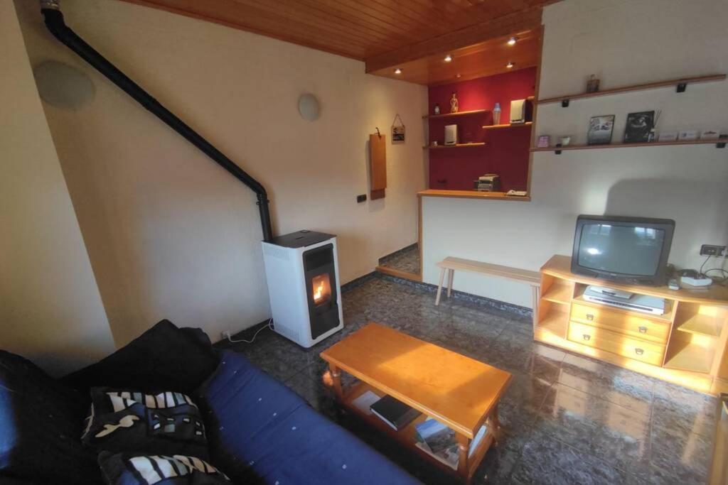 sala de estar con sofá azul y TV en Apartamento rural en Los Pirineos, en Guardiola de Berguedà