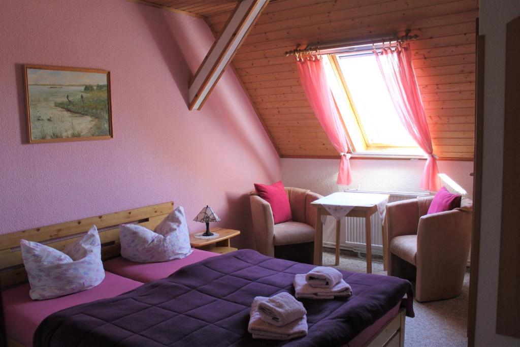 a bedroom with a bed and a table and a window at Pension Jägerrast in Boek