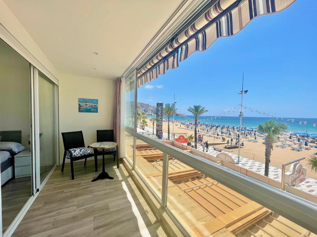 a room with a balcony with a view of a beach at Gemelos 1 Modern Seaviews in Benidorm