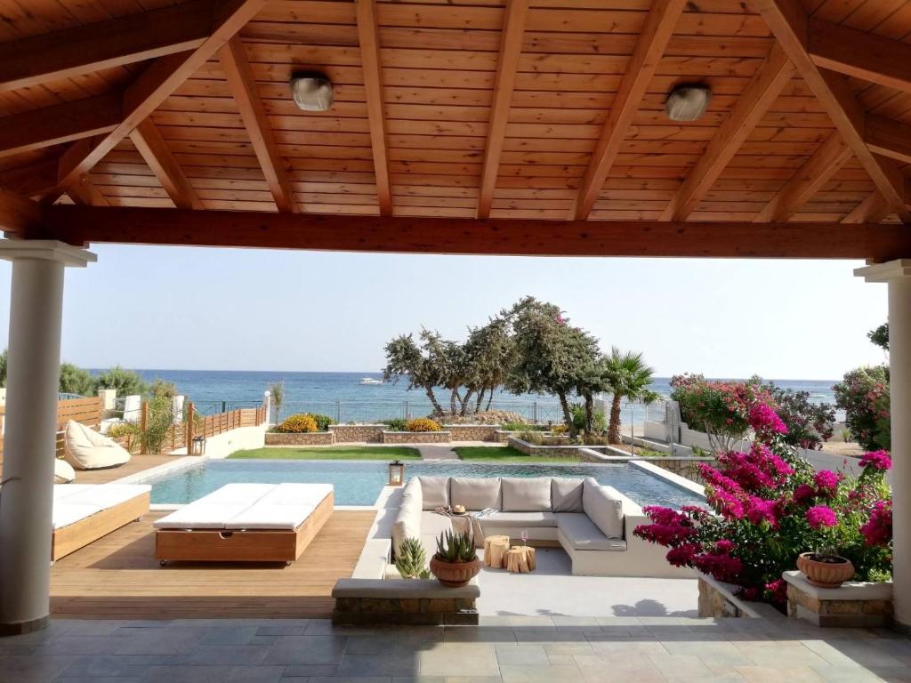 a patio with a pool and a wooden roof at Villa Del Nonno in Lardos