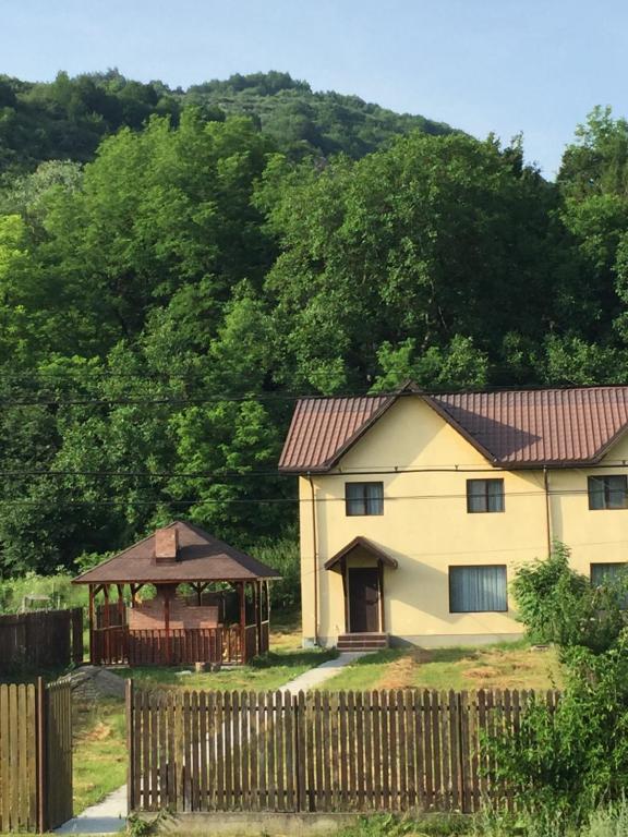 a house with a fence and a gazebo at Vila Maria in Buzau